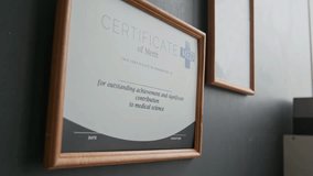 Certificate of Merit in wooden frame hanging on grey wall of modern medical office specializing in quality care for diabetic patients. - Powered by Shutterstock - Get 15% off with code: PIKWIZARD15