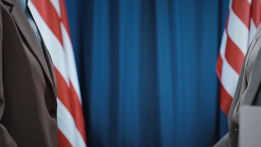 Medium shot of multiracial female political candidates from Democratic and Republican parties shaking hands after an election debate, illustrating politics and diplomacy.
