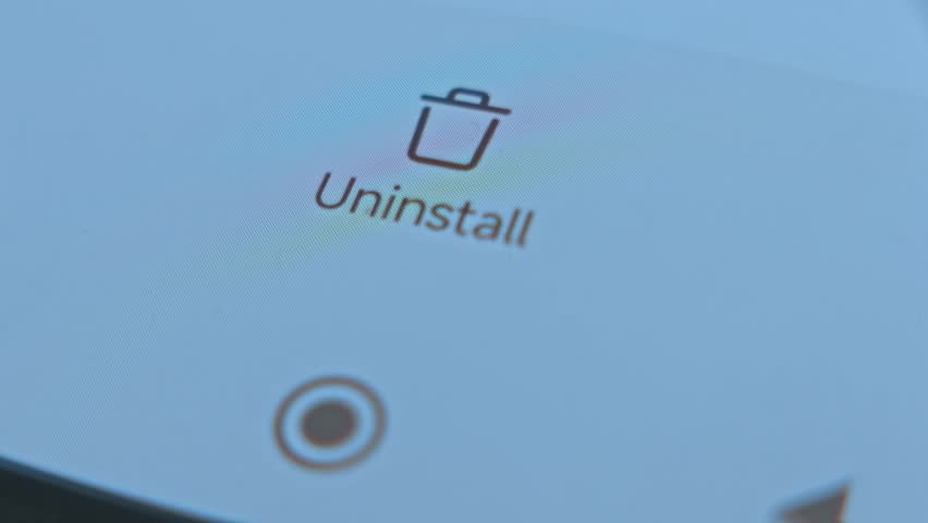 Close-up of a finger tapping the uninstall option on a smartphone, illustrating app management, mobile technology, and digital user interaction. - Powered by Shutterstock - Get 15% off with code: PIKWIZARD15