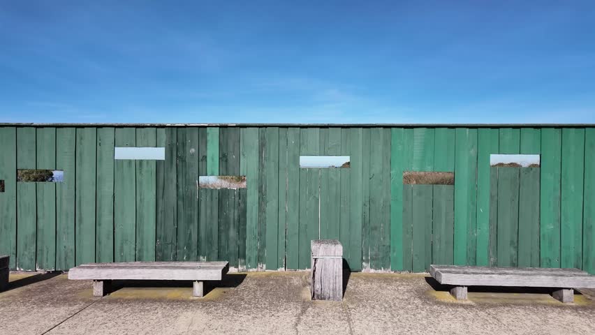 Wooden birdwatching shelter or bird hide with benches and viewing windows overlooking local wetlands or conservation in Williamstown, Melbourne Australia. Concept of wildlife observation.