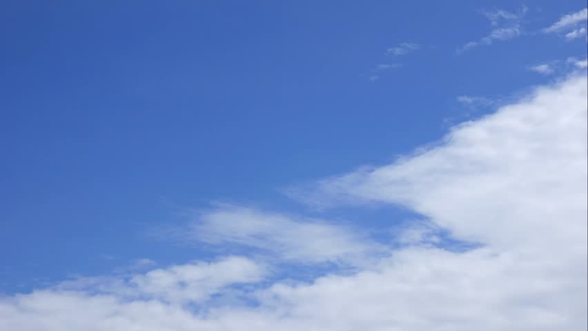 Time lapse of gentle clouds traveling across an open blue atmosphere creating calm visual rhythm and natural flow. Sky harmony.
