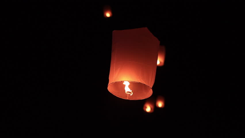 Sky lantern floating in the dark night sky, Tourist floating sky lanterns, Sky lanterns floating on night of Yi Peng, Loy Krathong Festival or Yi Peng Festival in Chiang Mai Thailand. 