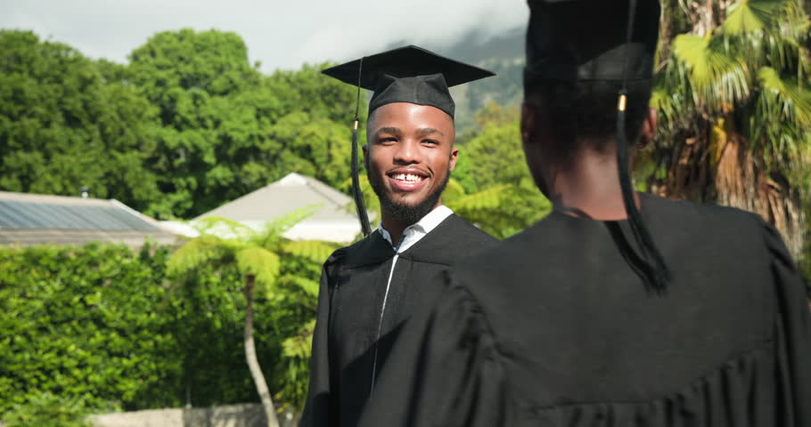 Graduating outdoors, young couple celebrating in caps and gowns, feeling joyful. Graduation, achievement, celebration, success, commencement, happiness