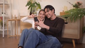 Young Asian adults capture joyful selfie on smartphone. Shared moment love bonding in cozy home modern living space. Enjoying digital lifestyle. - Powered by Shutterstock - Get 15% off with code: PIKWIZARD15