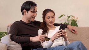 Young Asian couple happily engage online shopping at home using mobile phone and credit card for secure digital financial transaction - Powered by Shutterstock - Get 15% off with code: PIKWIZARD15