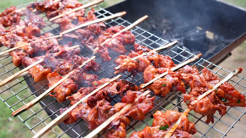 Sizzling grilled chicken skewers on barbecue grill showcase delicious array of marinated meat, filling air with smoky aroma, perfect for outdoor cooking and enjoyable gatherings