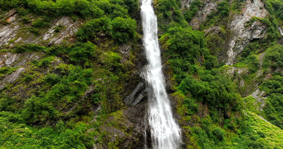 Rising along the beautiful waterfall on a high rock. One of the waterfalls in the wilderness of Alaska, USA.