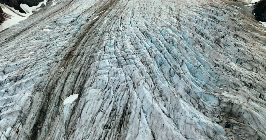 Flying over the ridged surface of the old glacier. Snow lies on the rocks around. Alaska, USA.