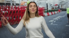 Young woman dancing joyfully on busy city street with vibrant red construction barriers and blurred workers in the background, showcasing urban outdoor happiness and movement. - Powered by Shutterstock - Get 15% off with code: PIKWIZARD15