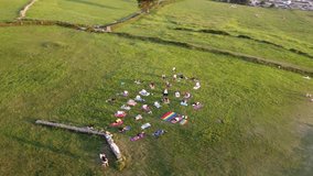 A diverse group of adults practicing yoga together on a sandy beach during sunset. This clip highlights community, healthy living, inclusion, fitness, and collective wellness outdoors - Powered by Shutterstock - Get 15% off with code: PIKWIZARD15