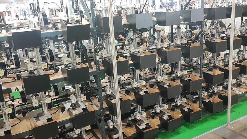 Many 3D printers printing an object. 3D printers simultaneously printing model from molten plastic. 3D printers creating shape from molten plastic flowing out of extruder.