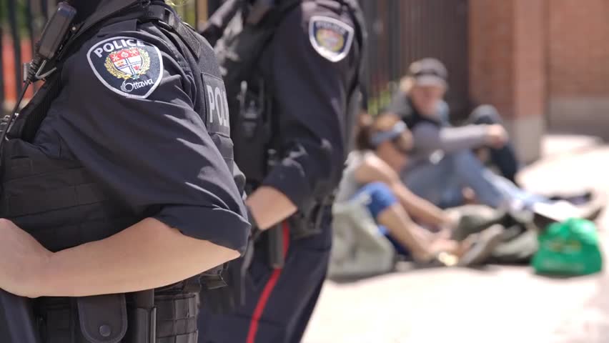 Police officers monitoring a safe injection site, highlighting the fight against fentanyl addiction and community health response to the opioid crisis.