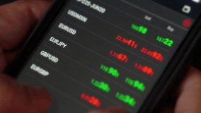 Close-up view of a person using a smartphone to trade stocks with live market data, charts, and prices displayed on the mobile screen. - Powered by Shutterstock - Get 15% off with code: PIKWIZARD15