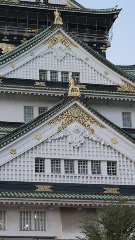 4k establishing shot of Osaka castle during bright sunset.