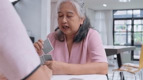 Senior Card Game: Capturing the essence of quality time, a gray-haired woman intently plays a card game with an unseen opponent. - Powered by Shutterstock - Get 15% off with code: PIKWIZARD15