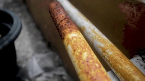 Footage displays a close up of two white metal pipes with rust on a tiled surface, showing aging and weathering, ideal for industrial, decay, or construction themes. - Powered by Shutterstock - Get 15% off with code: PIKWIZARD15