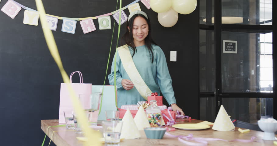 colleagues celebrating at baby shower party and cleaning food and decorations after party in office. Teamwork, celebration, business and communication concept.