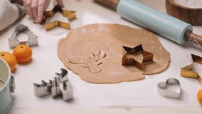 Person uses a cookie cutter to shape cookies from rolled-out dough, preparing for holiday baking. - Powered by Shutterstock - Get 15% off with code: PIKWIZARD15