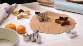 Person uses a cookie cutter to shape cookies from rolled-out dough, preparing for holiday baking. - Powered by Shutterstock - Get 15% off with code: PIKWIZARD15