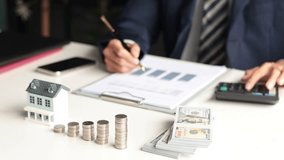 Real estate agent or investor, calculating or analyzing financial data related to property investment. Themes of saving, investing, and the financial aspects of purchasing a home or property. - Powered by Shutterstock - Get 15% off with code: PIKWIZARD15