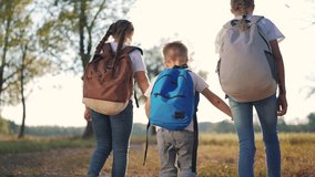 Group of children are walking in a forest with backpacks. Backpack nature child concept. Schoolchildren with backpacks walking in park. Children with backpacks walking in park in forest lifestyle. - Powered by Shutterstock - Get 15% off with code: PIKWIZARD15