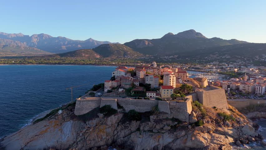 Aerial view of calvi citadel at sunrise with serene waters. Fortress with marina. Corsica. France