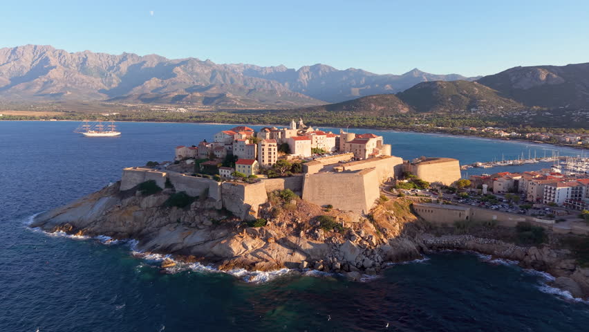 Aerial view of calvi citadel at sunrise with serene waters. Fortress with marina. Corsica. France
