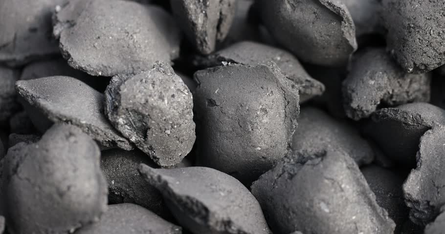 charcoal compressed from crumbs is obtained under pressure and used to light a fire and cook food on the grill, black charcoal in briquettes for barbecues