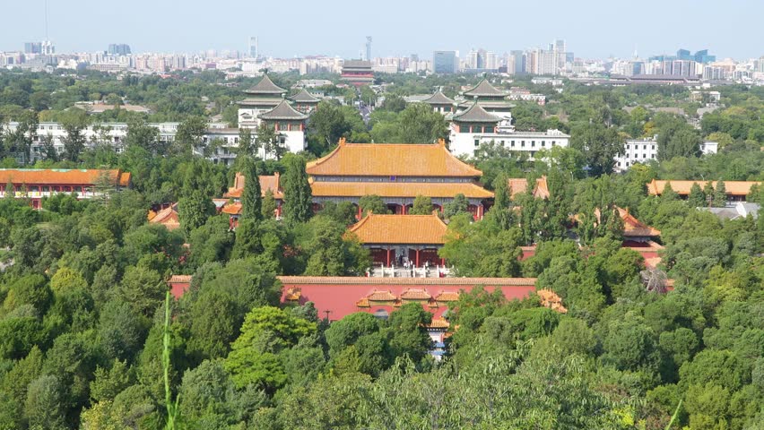Aerial view of Forbidden City imperial palace with traditional Chinese architecture, golden roofs, ancient buildings surrounded by lush greenery in Beijing, China.