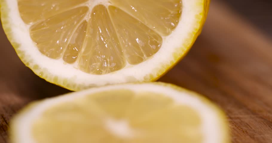 sliced juicy sour lemon lying on the table with green limes, sliced ripe citrus fruits lemon and limes are lying on a wooden table