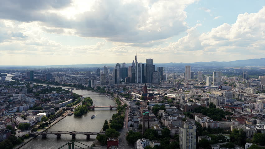 Aerial perspective of Frankfurt am Main financial district, showcasing modern skyscrapers, Main River, and cityscape on a cloudy day