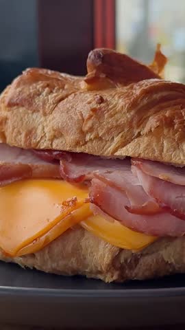  Croissant with jamon ham, Salmon, in Modern Cafe, Top View of Healthy Breakfast in Cafe. English breakfast: fried egg, bacon toast on sandwich.