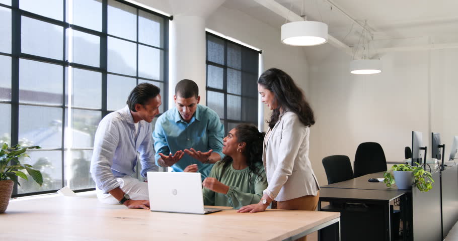 Happy diverse colleagues discussing work around laptop and celebrating in office. Teamwork, business, celebration and communication concept.