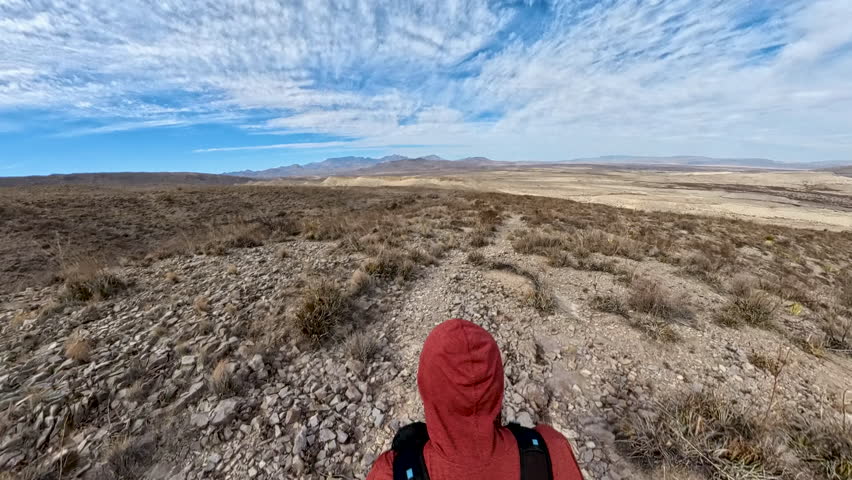 Overhead of Man Hiking on Desert Trail Toward the Chisos Mountains in Big Bend