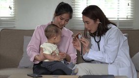 A woman doctor is examining a baby. The baby is sitting on a couch. The doctor is wearing a white coat - Powered by Shutterstock - Get 15% off with code: PIKWIZARD15