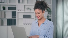 Portrait of young Latina businesswoman working in the modern office. Professional beautiful female employee feeling happy and relax, standing confidently near desk and look at camera in cozy workplace - Powered by Shutterstock - Get 15% off with code: PIKWIZARD15