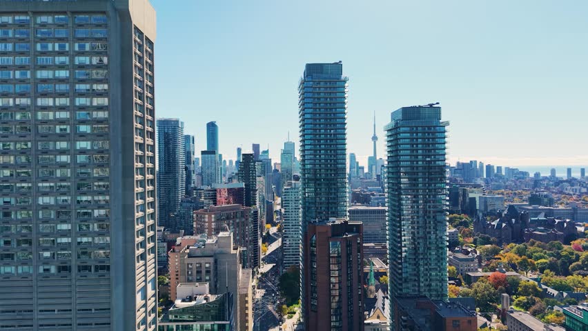 Spectacular panoramic drone view of modern Downtown skyscrapers and Lake Ontario against blue sky in Toronto, Ontario, Canada.