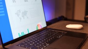 Professional man wearing a smartwatch working on a laptop with charts and graphs on the screen - Powered by Shutterstock - Get 15% off with code: PIKWIZARD15