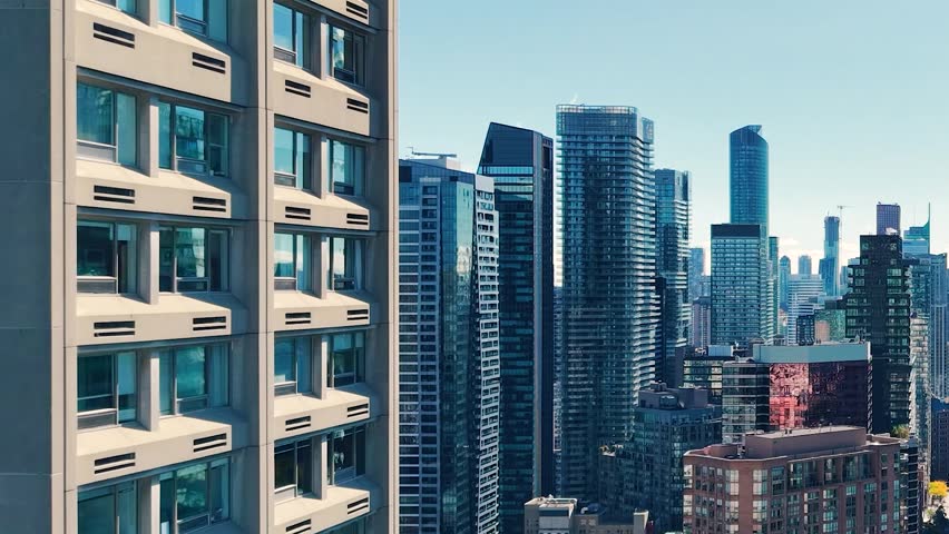 Spectacular panoramic drone view of modern Downtown skyscrapers and Lake Ontario against blue sky in Toronto, Ontario, Canada.