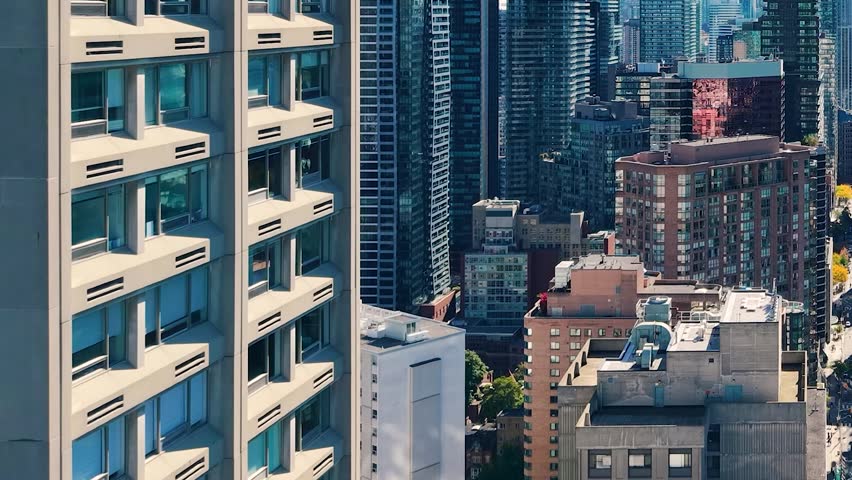 Spectacular panoramic drone view of modern Downtown skyscrapers and Lake Ontario against blue sky in Toronto, Ontario, Canada.