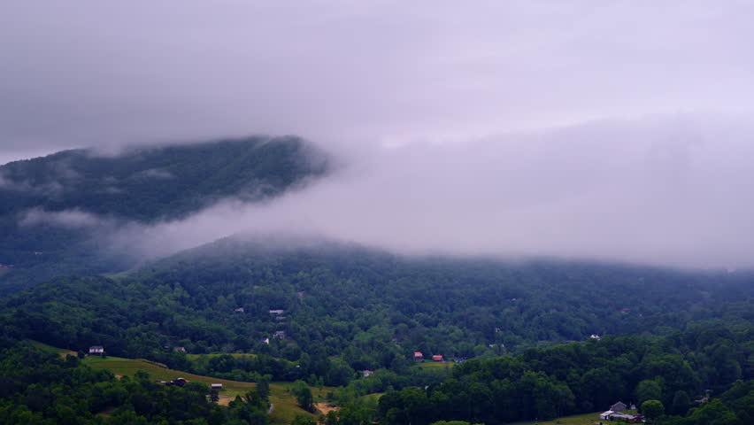 Aerial shot gliding over a dreamy, mist-filled Smoky Mountain landscape.
