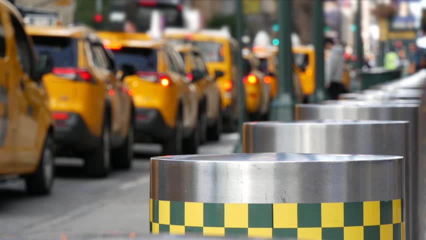 Manhattan Midtown street New York City, United States. Defocused row of yellow taxi cars. Many taxi cabs in line on 8th avenue near Penn Station. Taxi queue, urban road traffic, passenger transport.