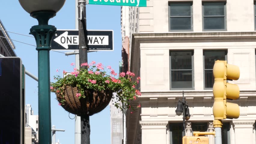 New York City Broadway street sign in Manhattan Midtown, United States. Urban road sign, traffic sign. Building architecture in Flatiron district. Crossroad with 5 fifth avenue. Subway metro entrance.