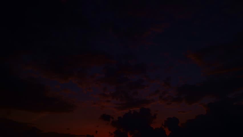 Sunset with sun and clouds on blue and orange dramatic sky with sun rays. Night Sky timelapse. Moving clouds at sunset. Evening Clouds. Dusk twilight sky time lapse. Dramatic sky.