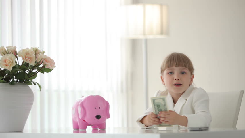 Little  businesswoman counting money and hugging piggy bank
