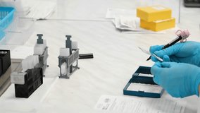 Close up of lab technician marking microscope slides with samples in clinical laboratory, scientific research and diagnostic preparation process in modern healthcare facility. - Powered by Shutterstock - Get 15% off with code: PIKWIZARD15