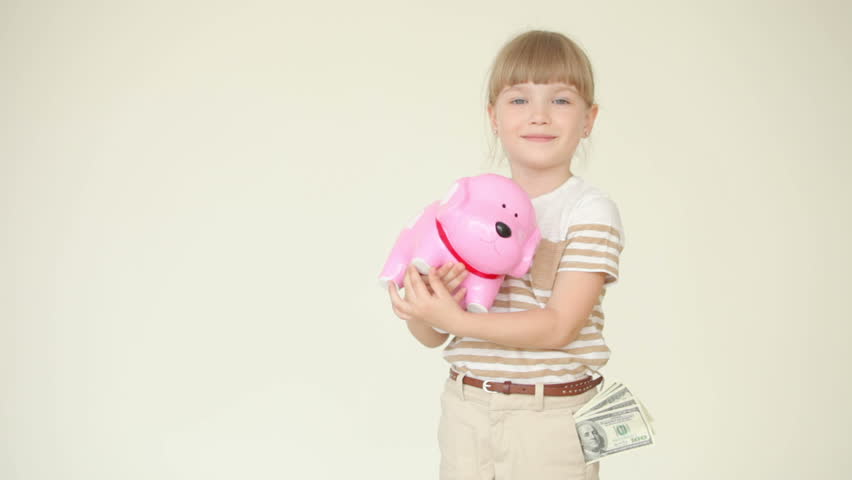 Girl holding a piggy bank with coins and shows ok
