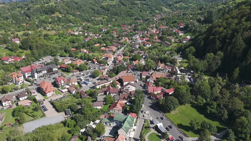 Aerial footage capturing the town of Bran, surrounded by rolling hills and beautiful Romanian scenery.