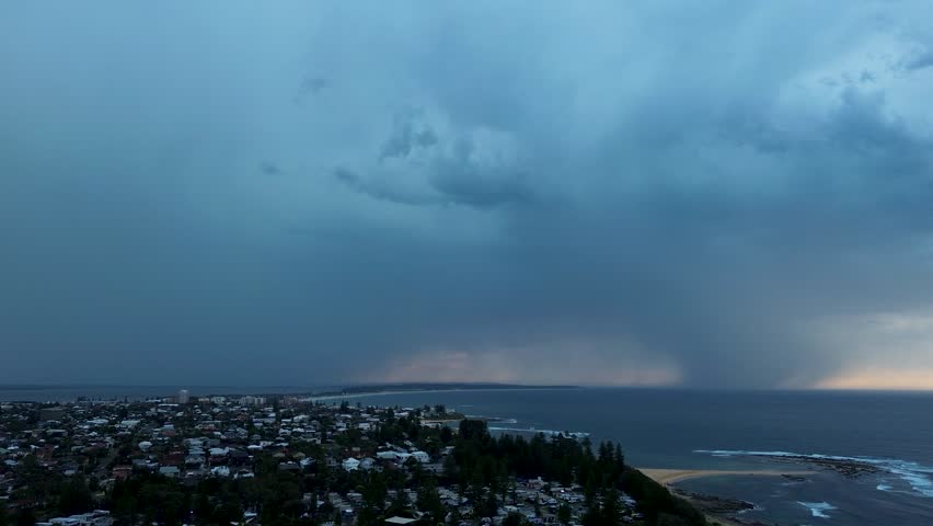 Drone aerial landscape of thunderstorm lightning strikes with dark looming clouds in sky over a suburban rural town on the Central Coast Australia nature environment climate and weather conditions