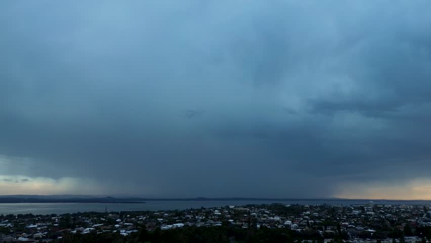 Drone aerial landscape of lightning strikes and zaps from looming storm clouds over suburban town and rural housing on a rainy morning in Long Jetty Central Coast Australia weather nature environment